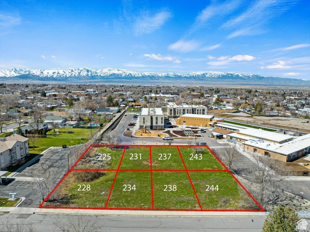 Aerial perspective of suburban area featuring a mountainous background and property boundaries highlighted