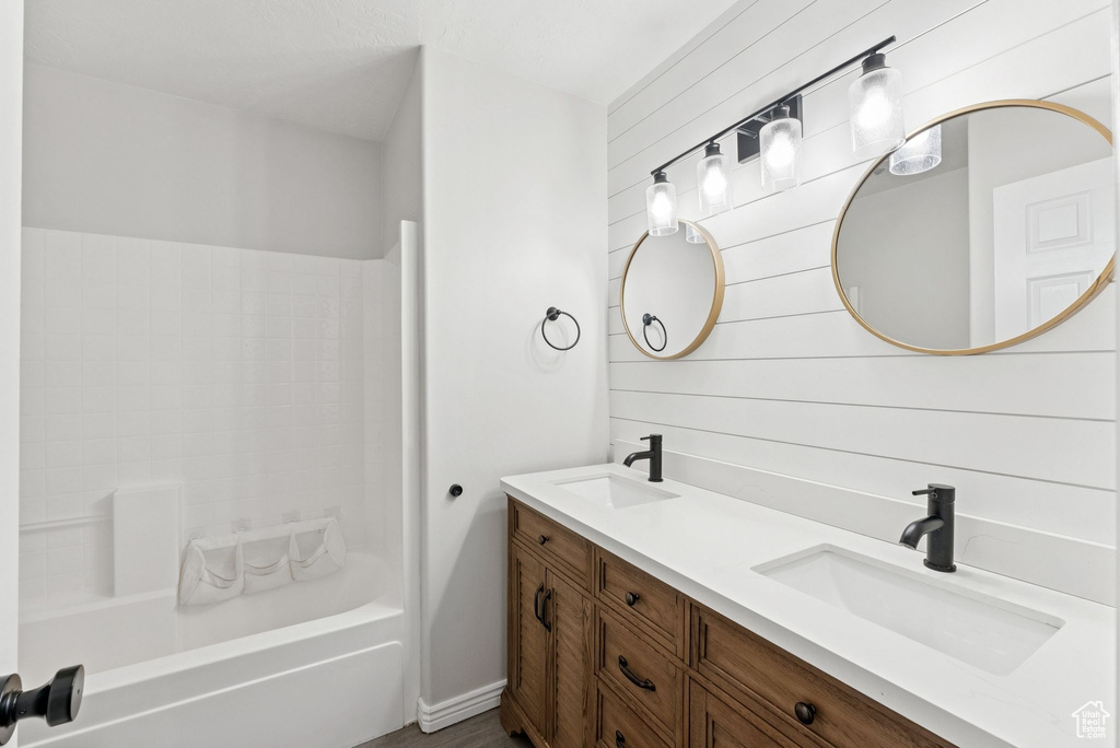 Bathroom featuring double vanity and tub / shower combination