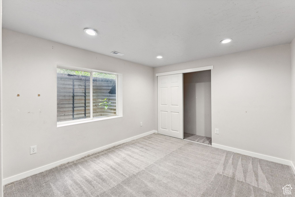 Unfurnished bedroom with carpet floors, recessed lighting, and a closet
