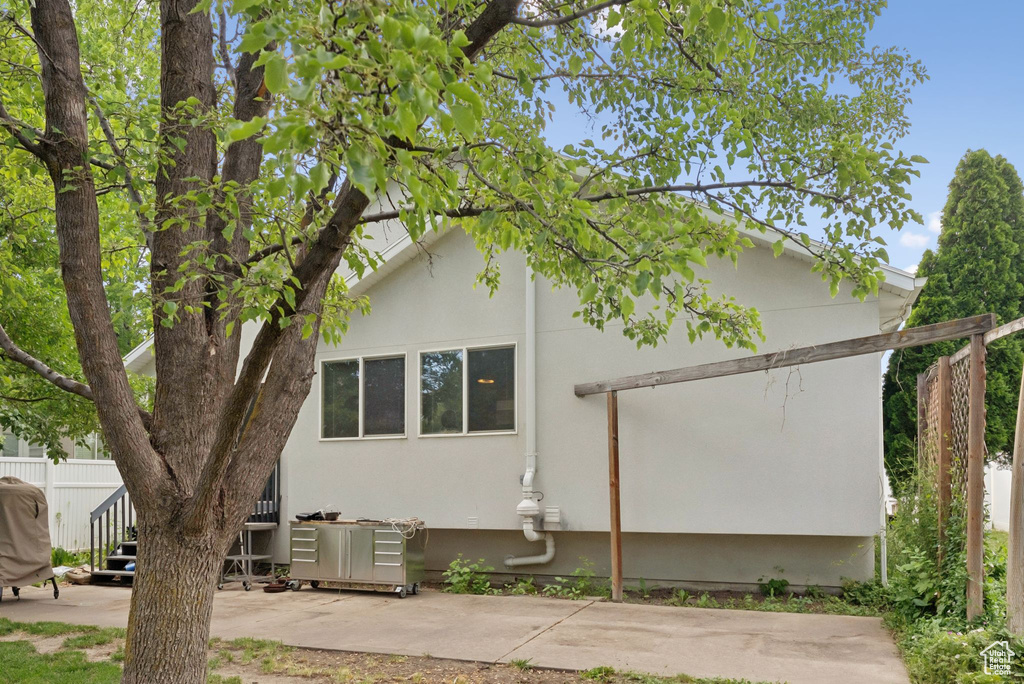View of side of property with a patio area and stucco siding
