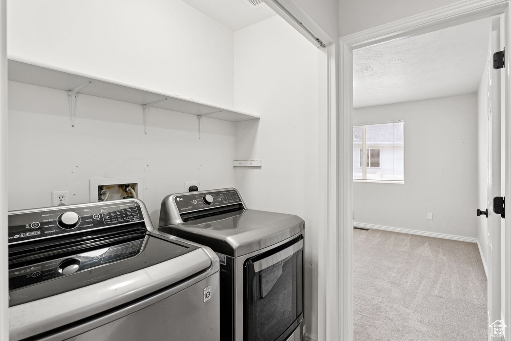 Laundry room featuring washing machine and clothes dryer and carpet floors