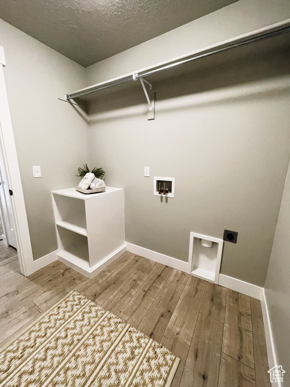 Laundry area featuring electric dryer hookup, wood finished floors, washer hookup, and a textured ceiling