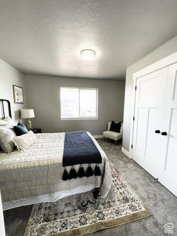 Bedroom with carpet and a textured ceiling