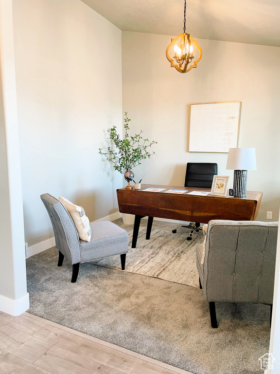 Office area with a chandelier and wood finished floors