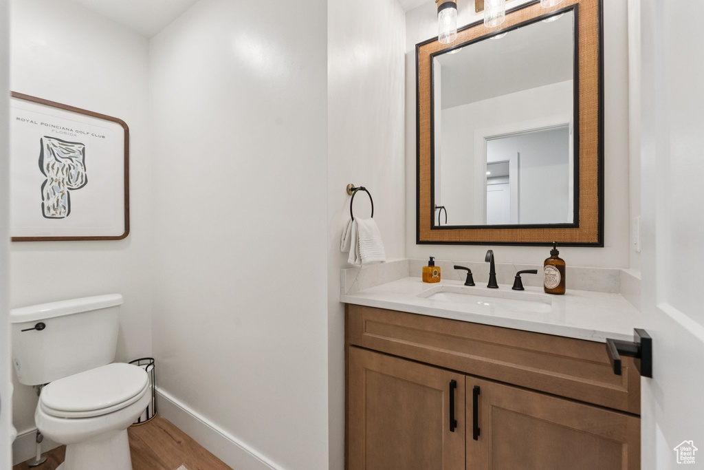 Half bathroom featuring vanity and wood finished floors