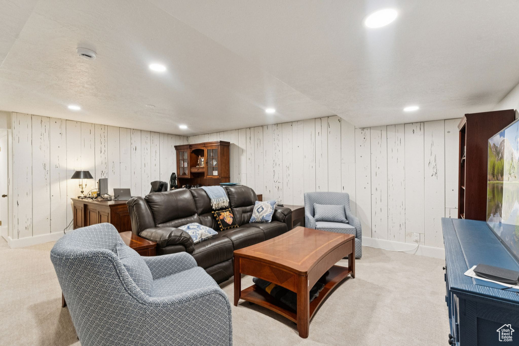 Living area with light carpet and recessed lighting