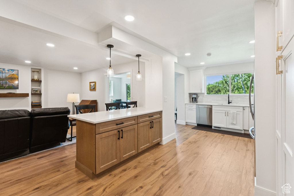 Kitchen featuring dishwasher, open floor plan, light wood-style flooring, decorative backsplash, and recessed lighting