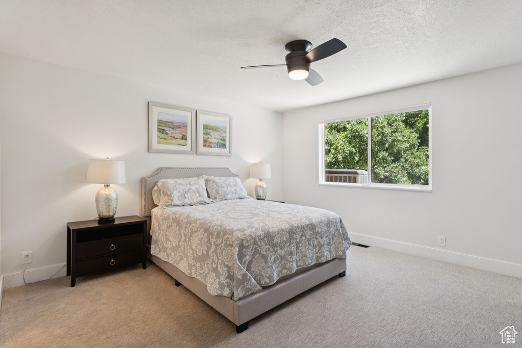 Bedroom featuring light carpet and a ceiling fan