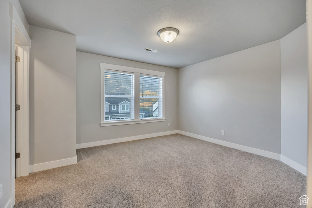 Unfurnished room featuring light carpet