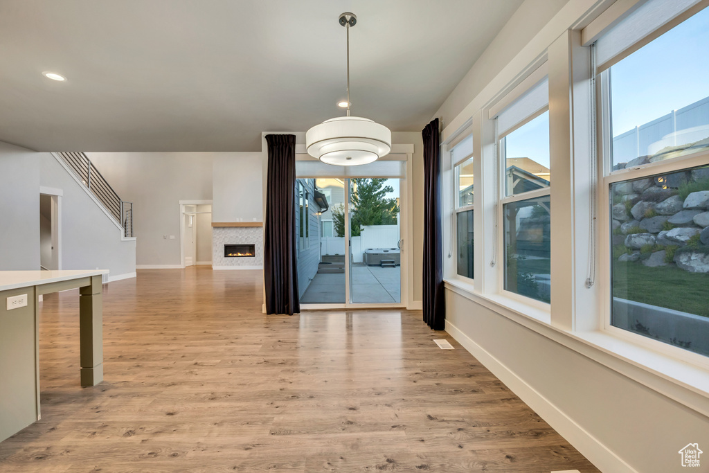 Unfurnished dining area with healthy amount of natural light, light wood-style floors, a fireplace, and recessed lighting