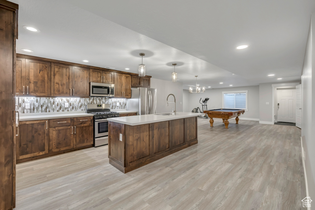 Kitchen with stainless steel appliances, recessed lighting, light wood finished floors, billiards table, and light countertops