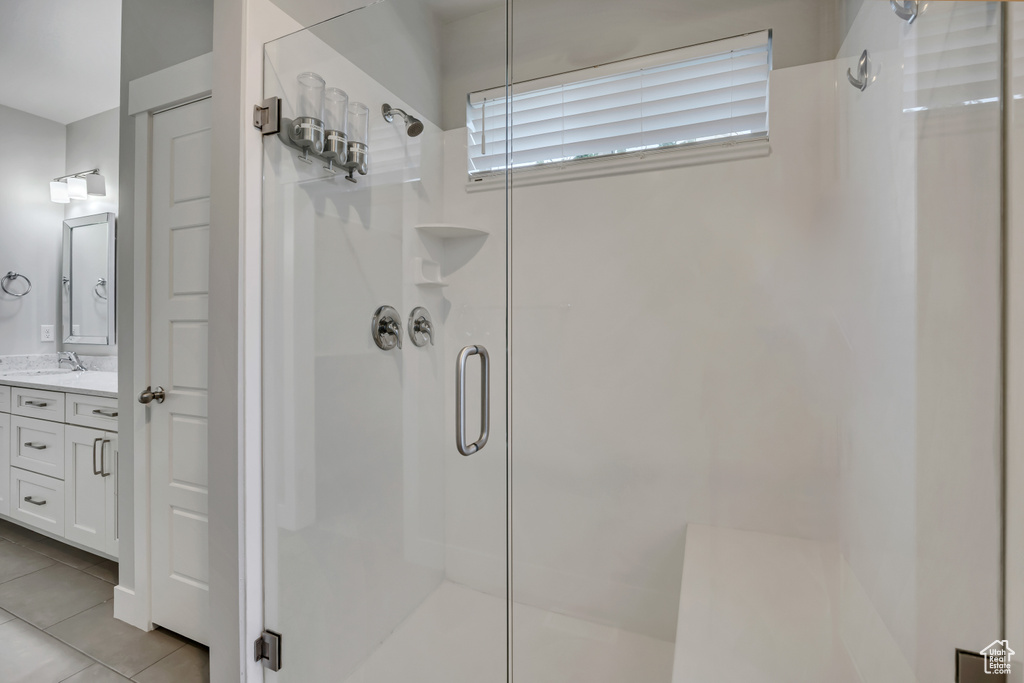 Bathroom with a stall shower, vanity, and tile patterned flooring