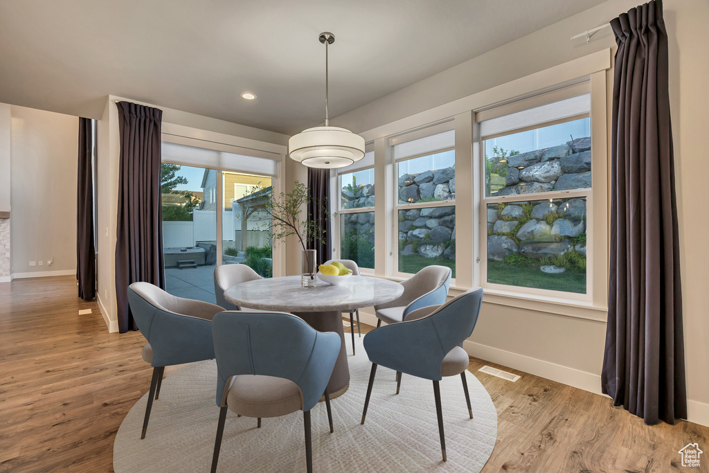 Dining area with light wood finished floors and recessed lighting