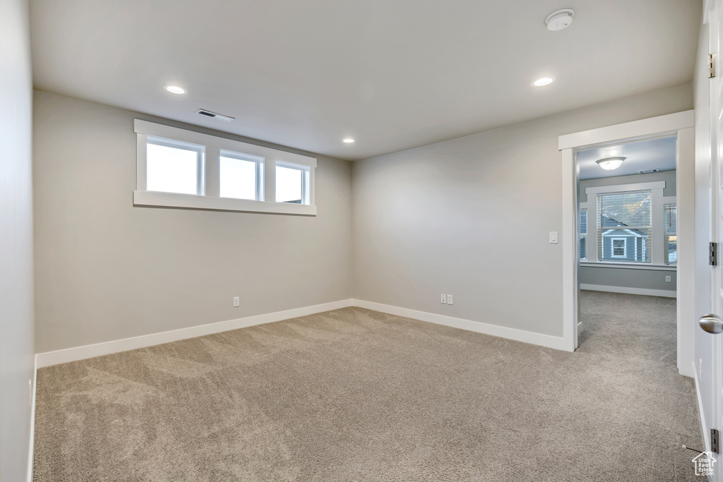 Carpeted spare room featuring a smoke detector and recessed lighting