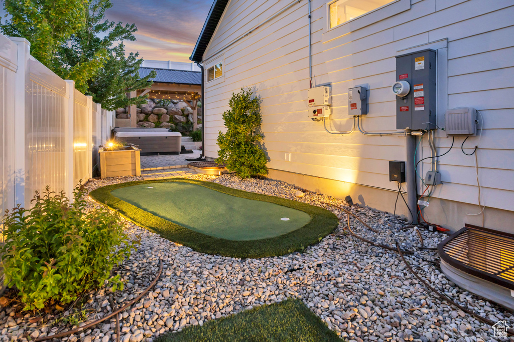 Fenced backyard featuring a putting area