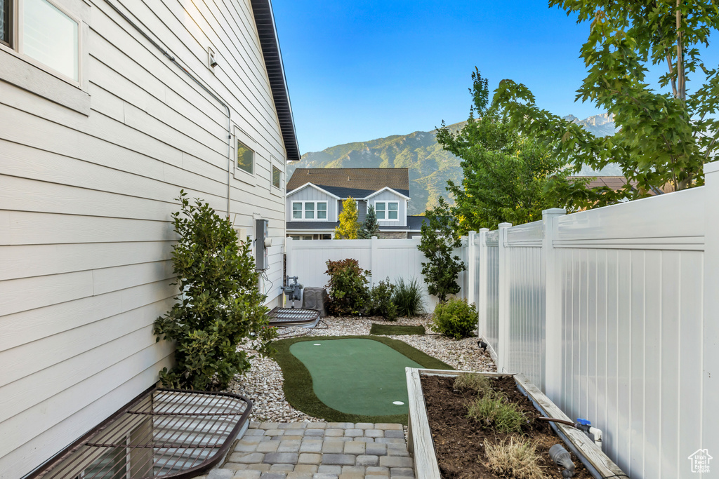 Fenced backyard with a putting green and a mountain view