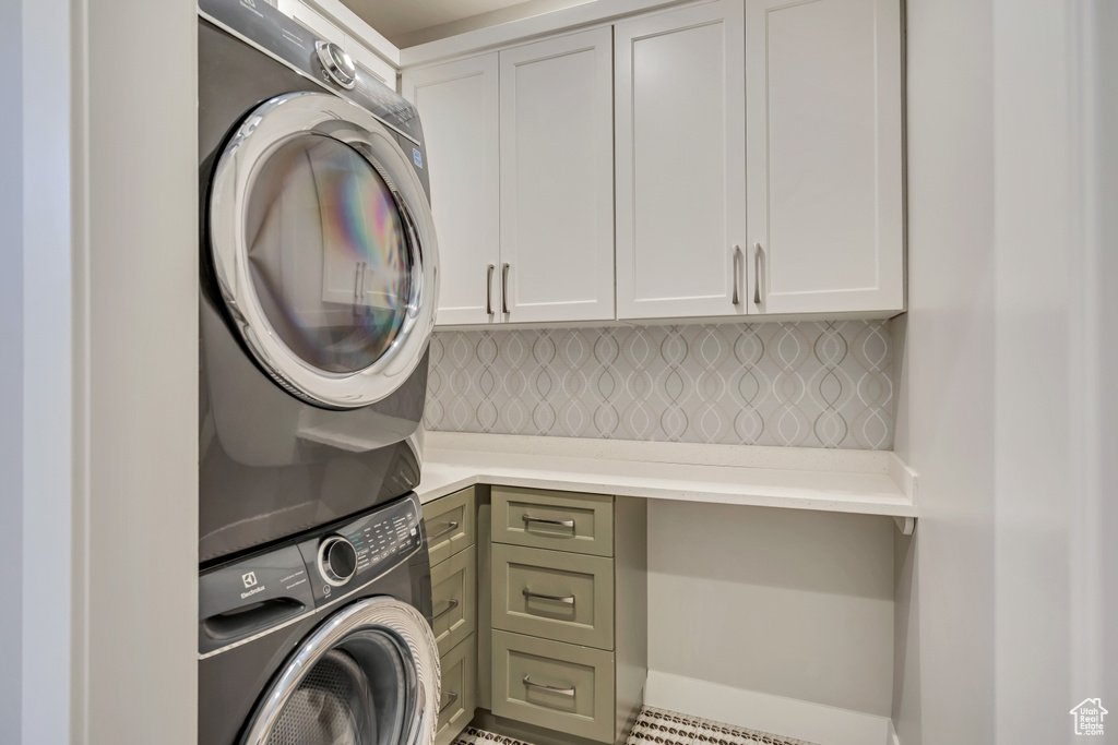 Laundry area with cabinet space and stacked washing machine and dryer
