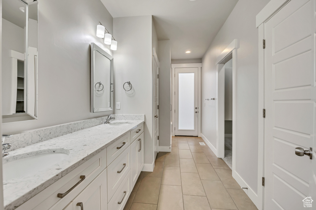 Bathroom featuring double vanity, tile patterned floors, and recessed lighting