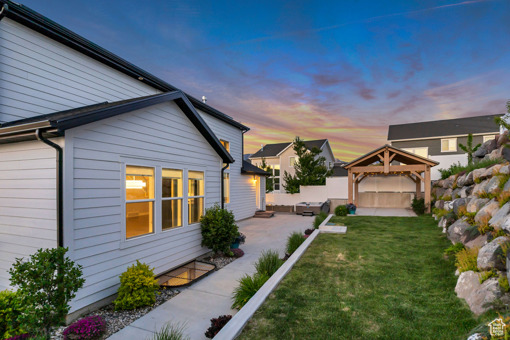 Yard at dusk with a gazebo and a patio area