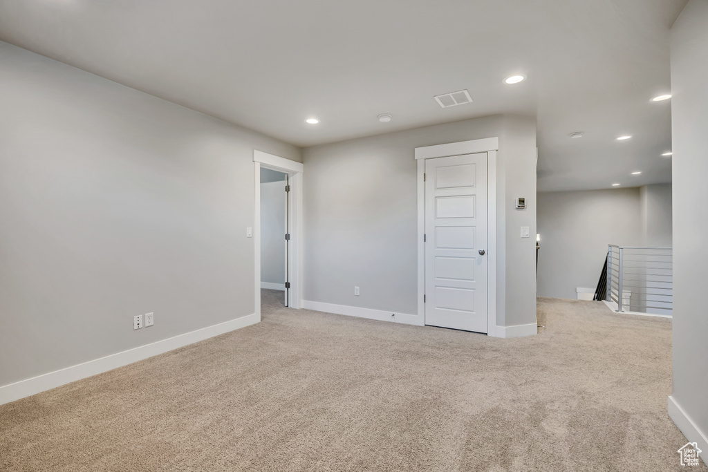 Carpeted empty room with recessed lighting and baseboards