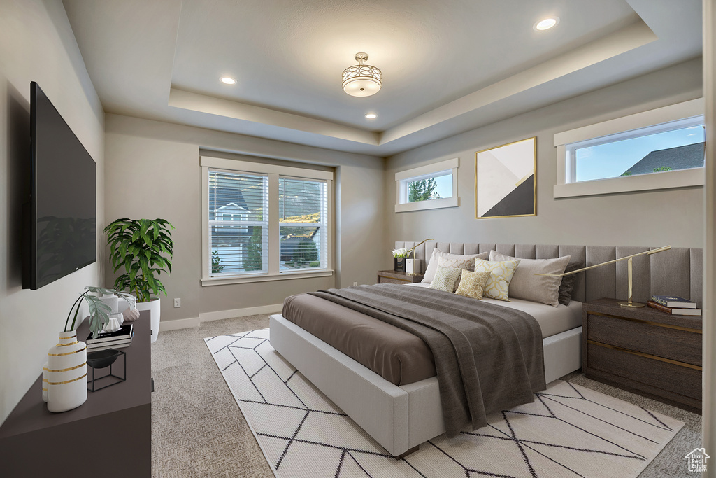 Bedroom featuring a raised ceiling, recessed lighting, and light carpet