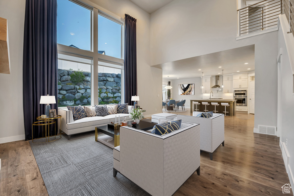 Living area with a high ceiling and dark wood-type flooring