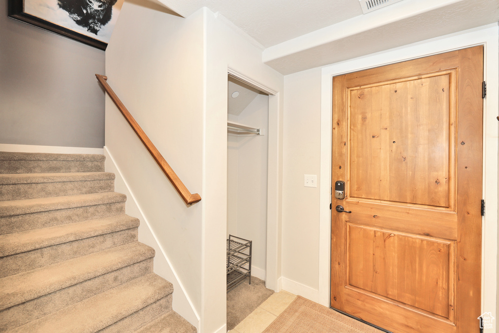 Foyer entrance with stairway and baseboards