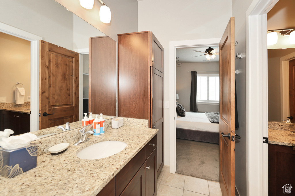 Ensuite bathroom featuring vanity, tile patterned floors, and ceiling fan
