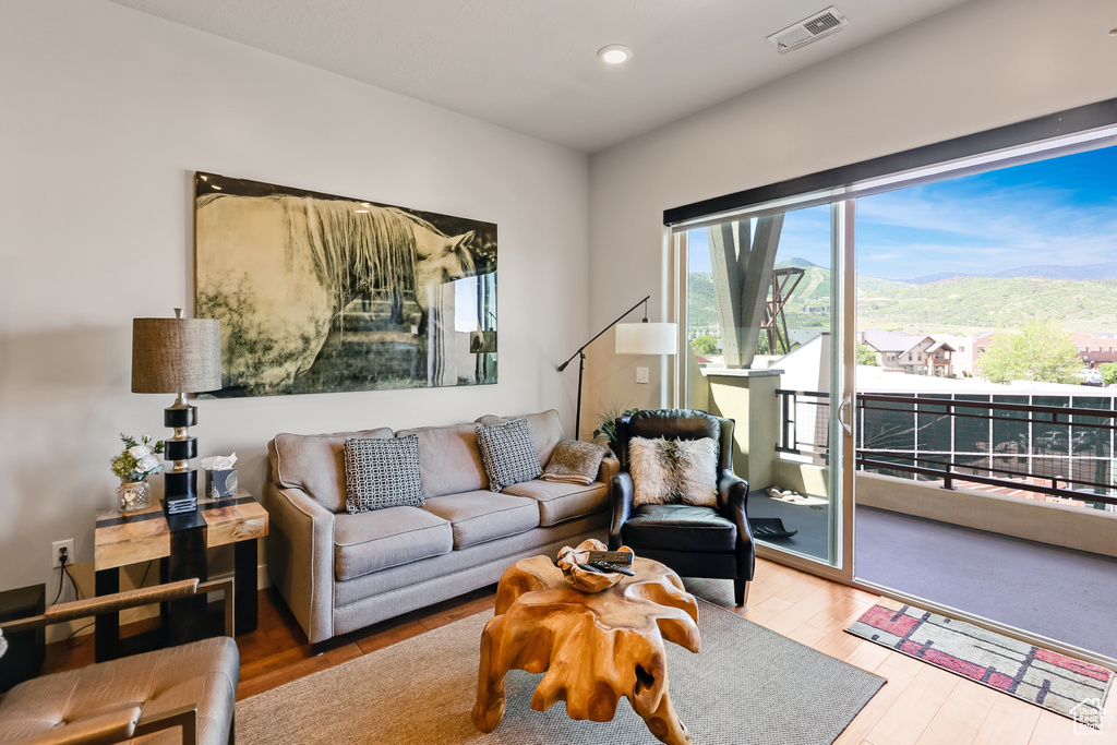 Living room with a mountain view, wood finished floors, and recessed lighting