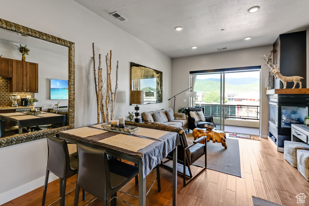 Dining area featuring light wood-type flooring, recessed lighting, and a textured ceiling