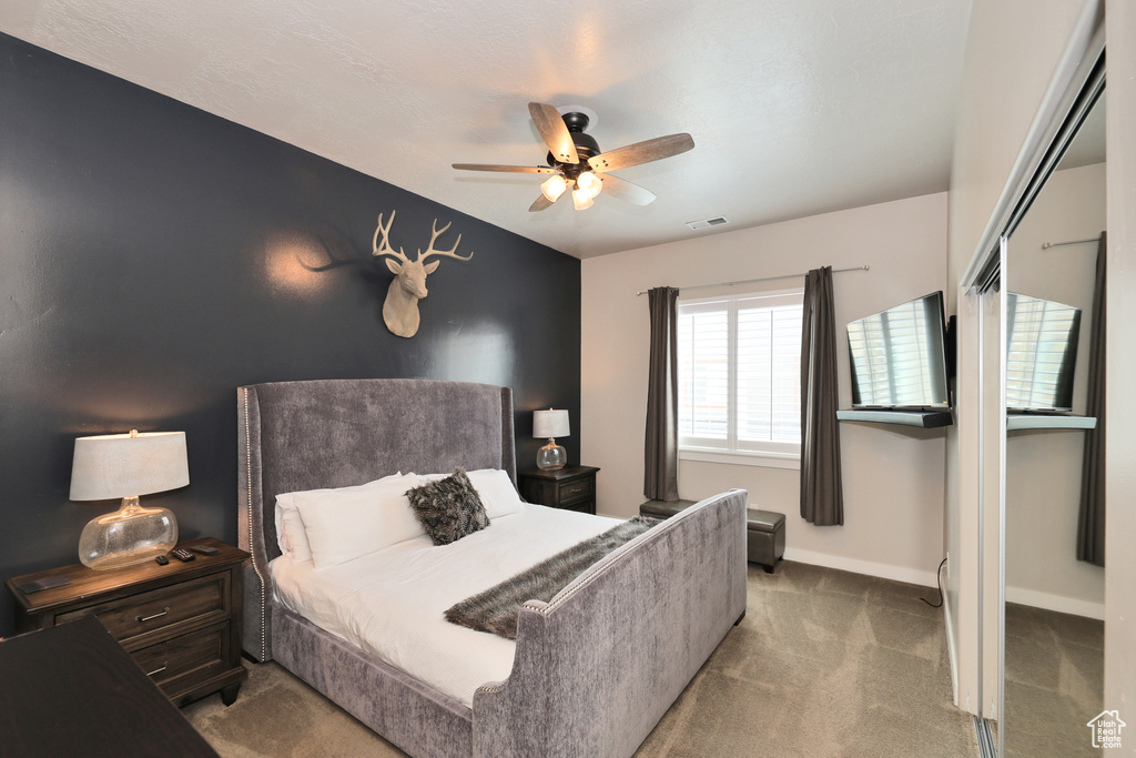 Carpeted bedroom with baseboards and a ceiling fan