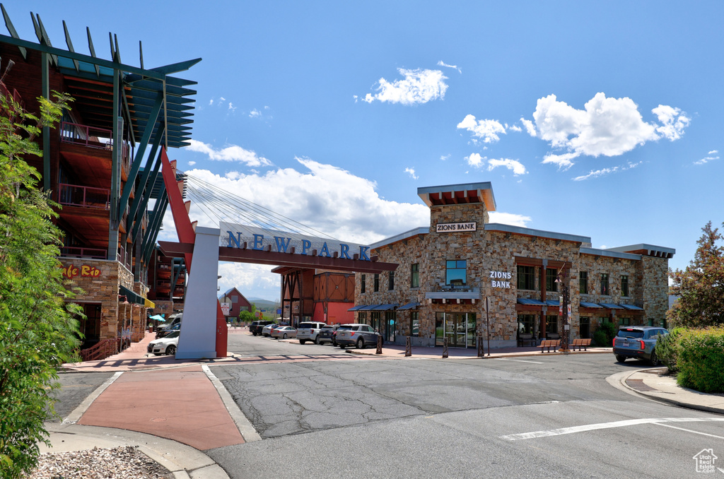 View of asphalt street featuring sidewalks, curbs, and street lighting