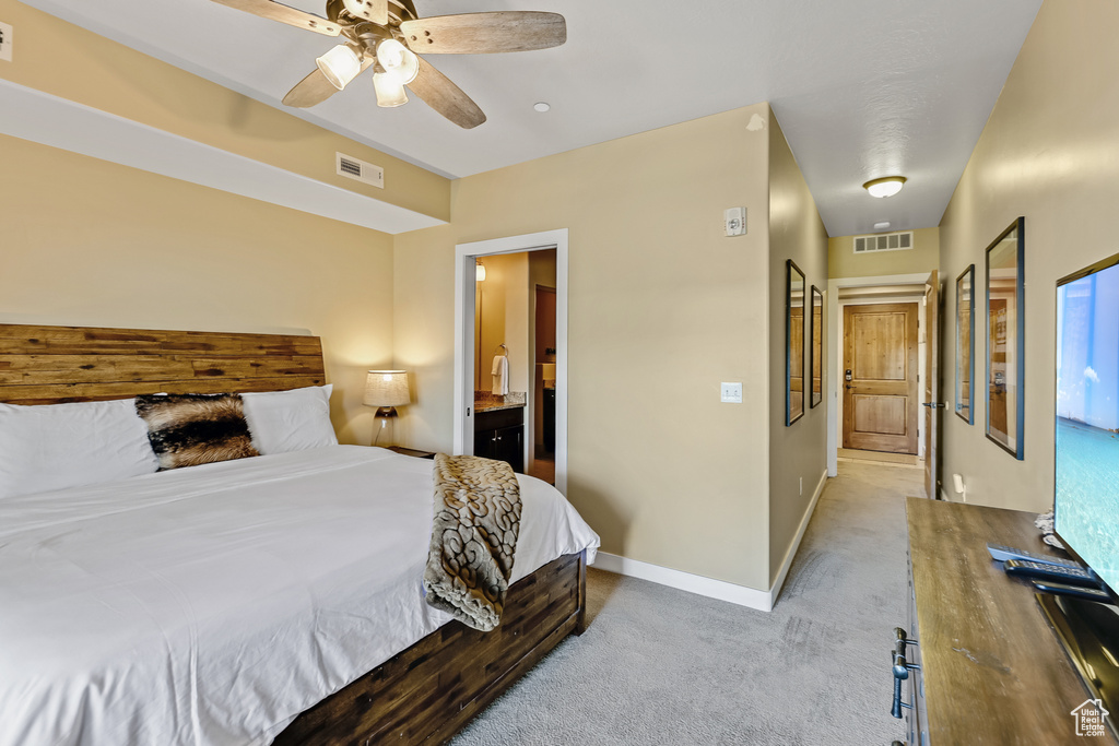 Carpeted bedroom featuring a ceiling fan and ensuite bathroom