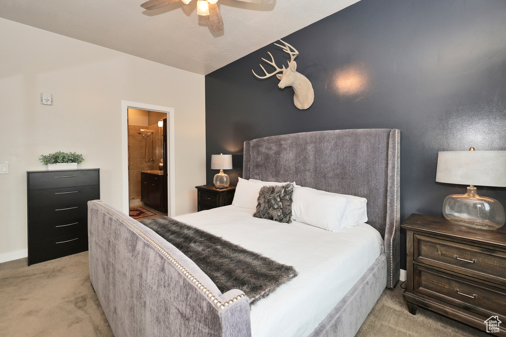 Bedroom featuring light colored carpet, ensuite bathroom, and ceiling fan