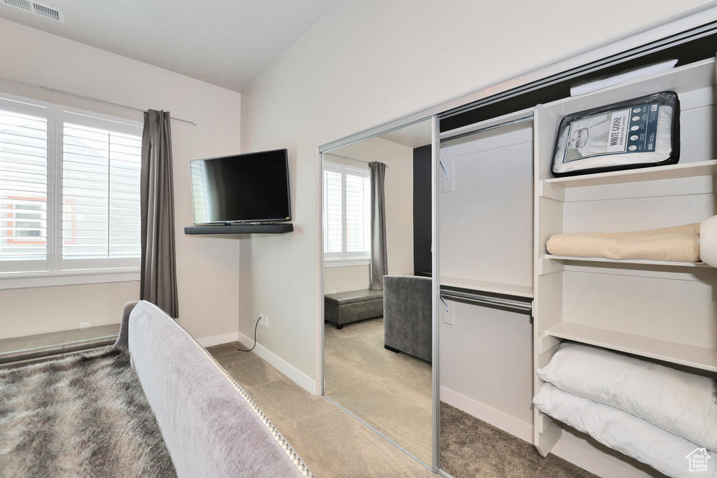 Unfurnished bedroom featuring light carpet and baseboards