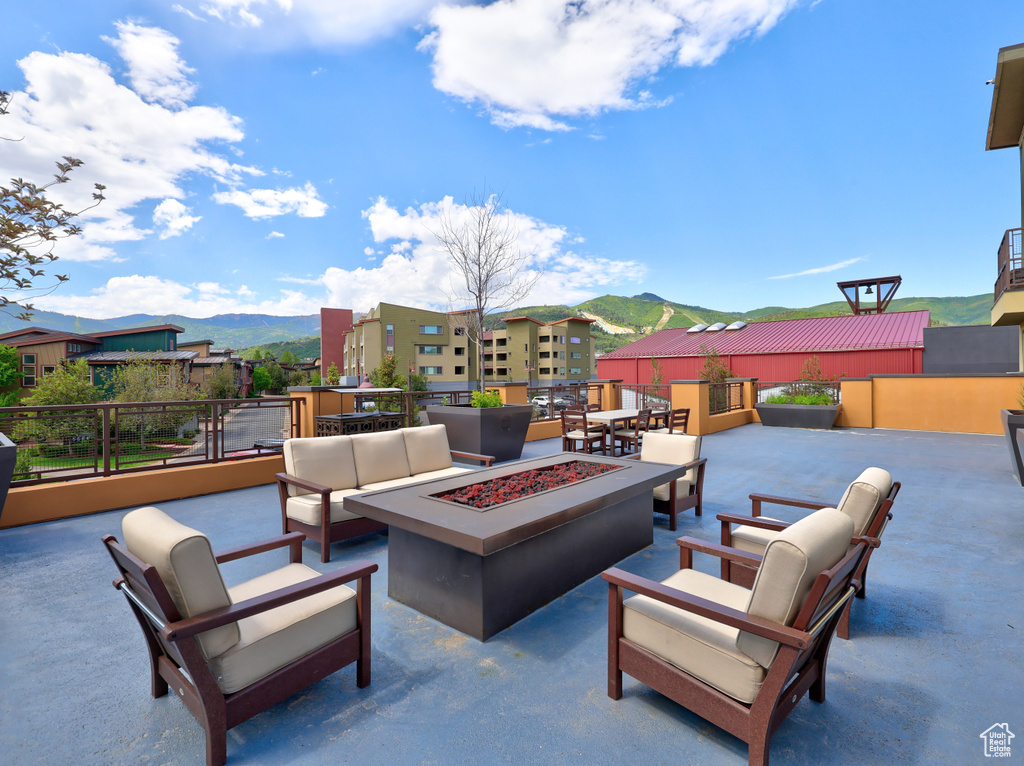 View of patio with a mountain view and an outdoor living space with a fire pit