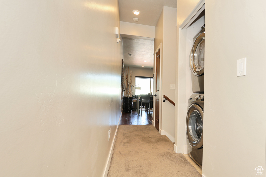 Laundry room featuring estacked washer and dryer and carpet flooring
