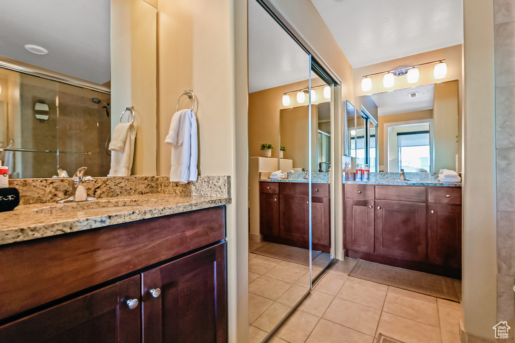 Bathroom with two vanities, tile patterned flooring, and a stall shower