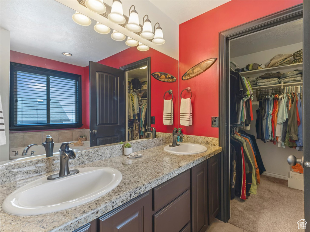 Bathroom featuring double vanity and a spacious closet