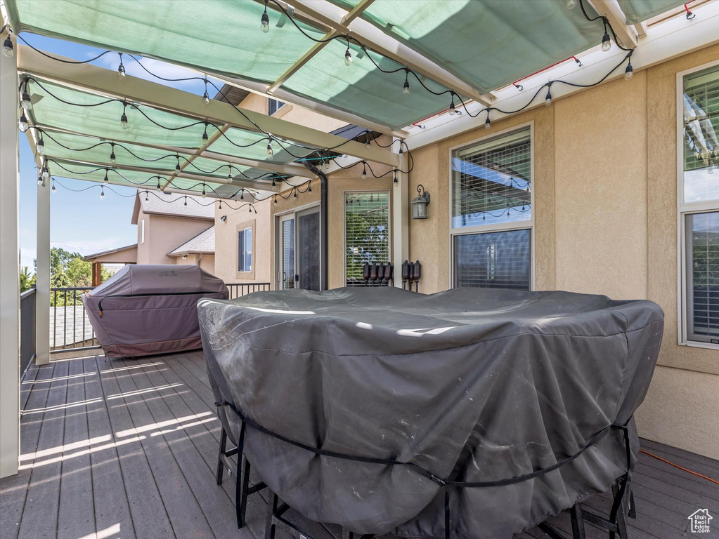 Wooden deck with area for grilling and a pergola