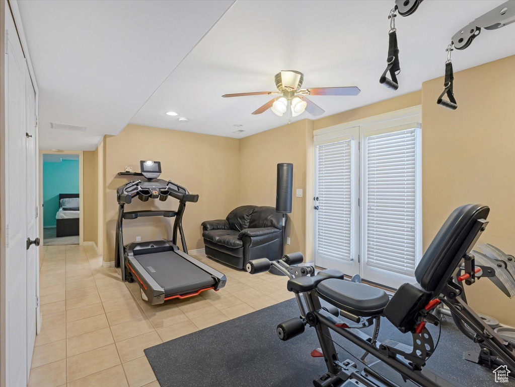 Exercise room with a ceiling fan and light tile patterned flooring