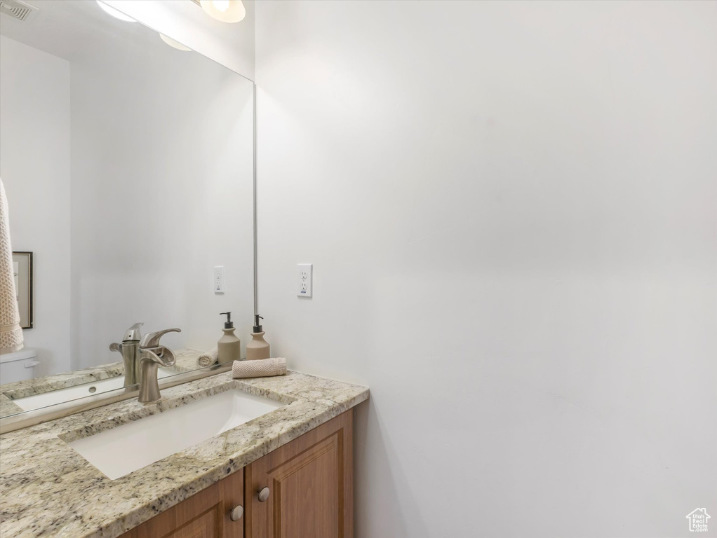 Half bathroom featuring vanity and toilet