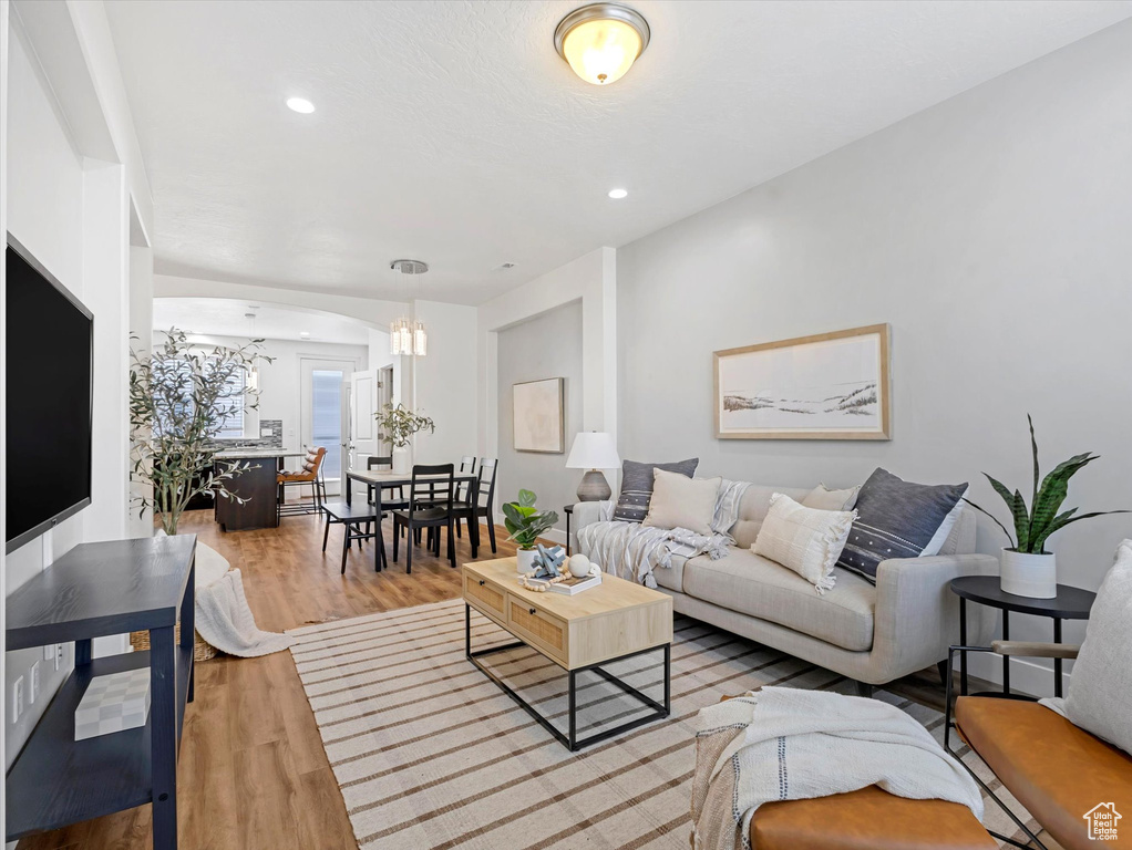 Living room with a chandelier, wood finished floors, and recessed lighting