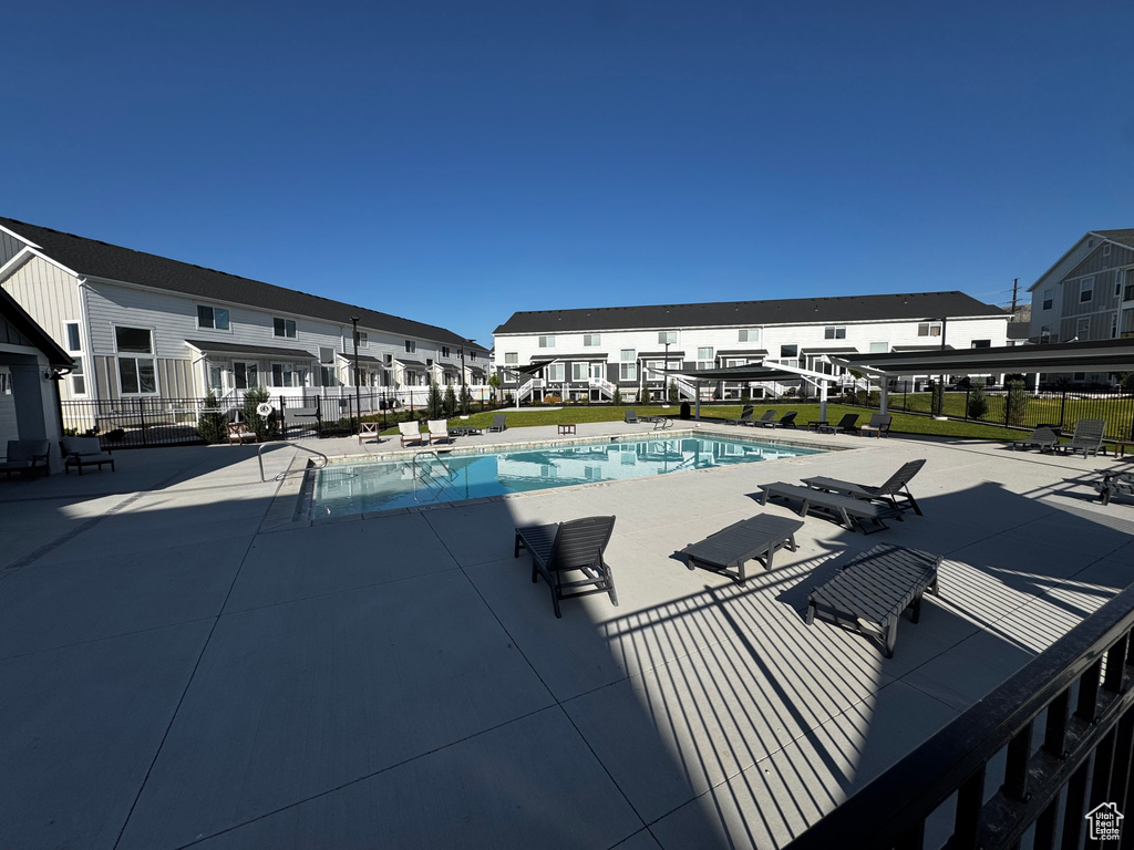Community pool with a patio area and a residential view