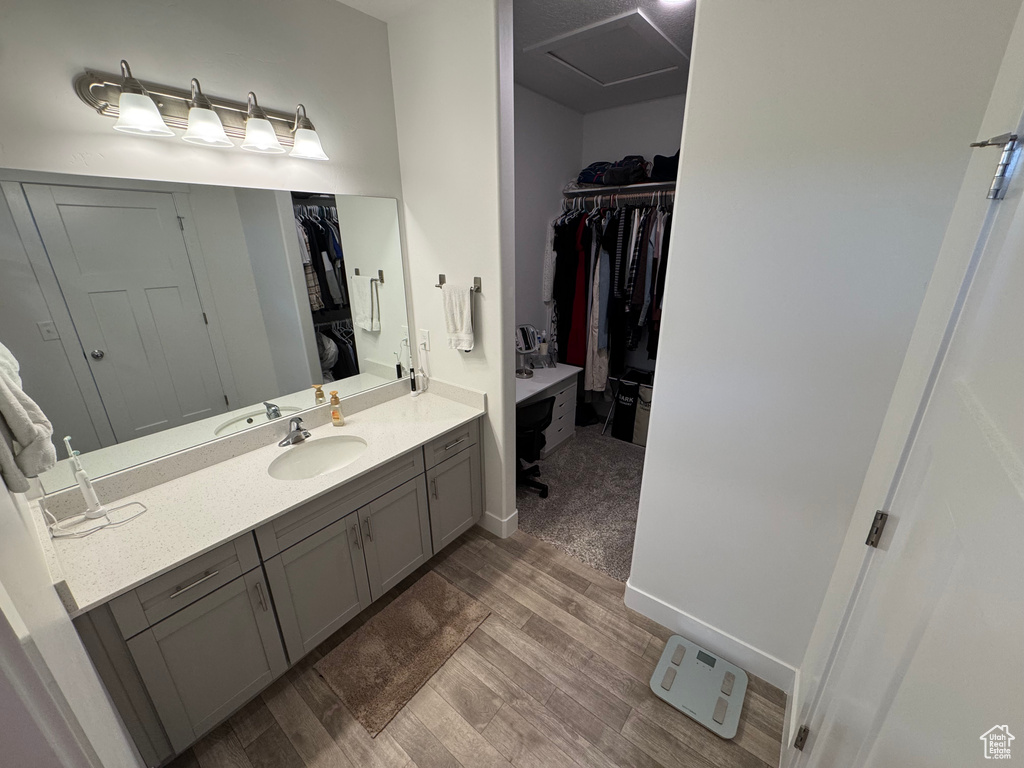 Full bath featuring wood finished floors, a walk in closet, and vanity
