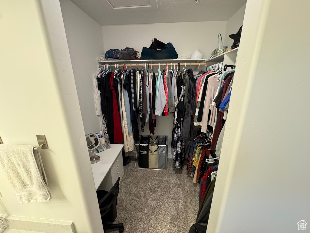 Spacious closet with carpet floors and attic access