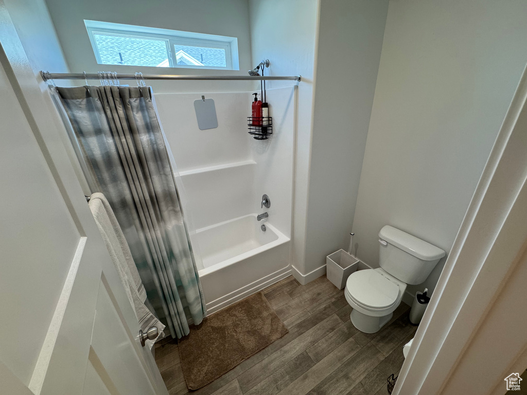 Bathroom featuring shower / tub combo and wood finished floors