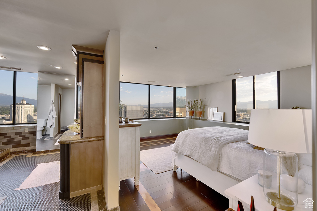 Bedroom featuring multiple windows, dark wood-style floors, recessed lighting, a mountain view, and a wall of windows