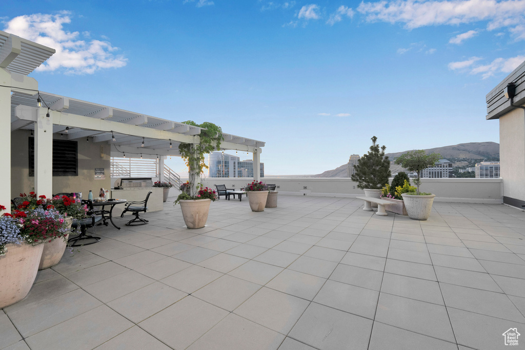 View of patio / terrace with a pergola, a mountain view, and outdoor dining space