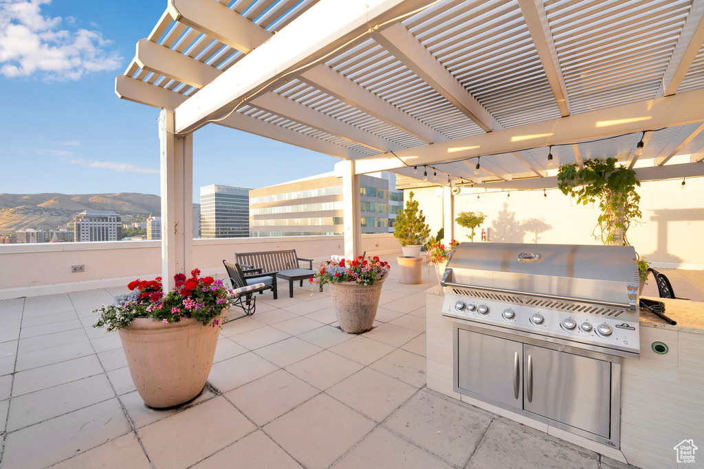 View of patio / terrace with grilling area, a pergola, and a mountain view